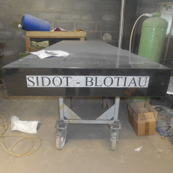 Gravure artisanale de lettres à la main sur pierre tombale, finition personnalisée et soignée