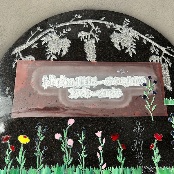 Incrustation de pâte de verre colorée sur pierre tombale, décoration artisanale et unique