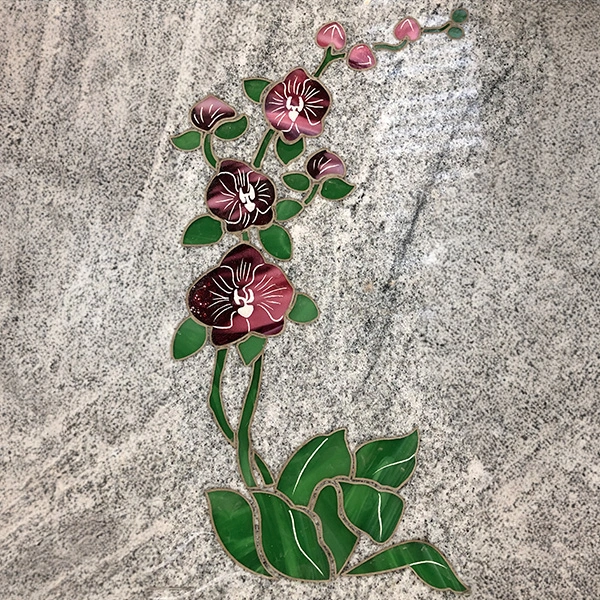 Incrustation de pâte de verre colorée sur pierre tombale, décoration artisanale et unique